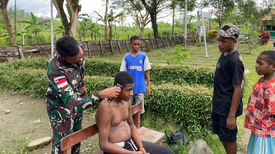 Personil Satgas Pamtas Statis RI-PNG Yonif 122/TS Pos Waris Membantu Anak-anak Berpenampilan Rapi